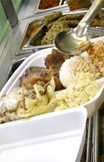A Marujyu plate lunch in a foam box: kalua pig, laulau, cabbage and two scoops of rice